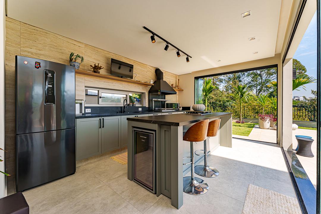 Ilha da área gourmet da Casa X-18 com tampo em lâmina ultracompacta Pietra Grey e banquetas